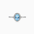 White gold ring with blue topaz and diamond halo design