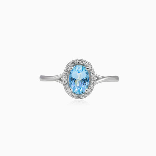 White gold ring with blue topaz and diamond halo design