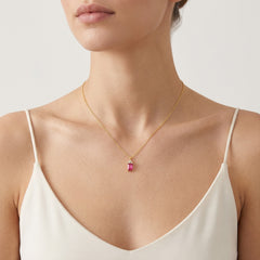 A beautiful gold necklace with a synthetic ruby pendant