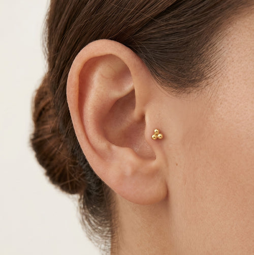 Elegantes Gold-Piercing mit dreifachem Kugeldesign