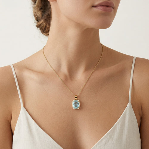Gelbgoldenes Pendant mit Kissen-Schliff Blau-Topas und Halo-Design.