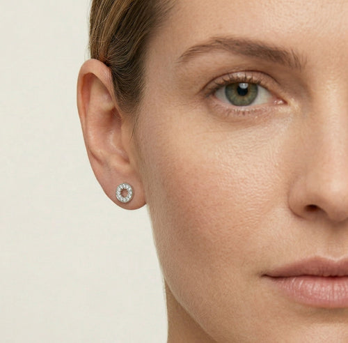 Pendientes redondos de plata con circonitas cúbicas alrededor.