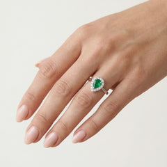Elegant white gold women's ring with diamonds and emerald