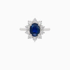 Klassischer Damenring aus 18 Karat Weißgold mit einem blauen Saphir im Ovalschliff und einem Halo aus Diamanten im Brillantschliff.
