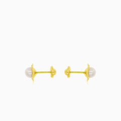 Gold earrings with an engraved flower outline and a white round pearl
