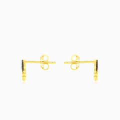 Gelbgoldene Ohrringe mit schwarzem Onyx-Kreis.