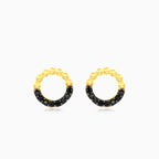 Gelbgoldene Ohrringe mit schwarzem Onyx-Kreis.