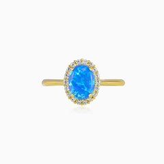 Anillo de oro con ópalo azul ovalado y halo