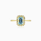 Halo-Ring aus Gold mit blauem Topas im Smaragdschliff