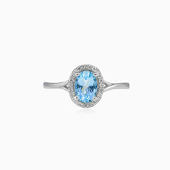 White gold ring with blue topaz and diamond halo design