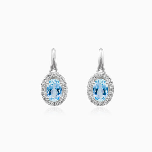 White gold earrings with blue topaz and diamond halo design