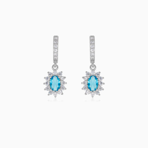 Halo silver dangling earrings with blue topaz