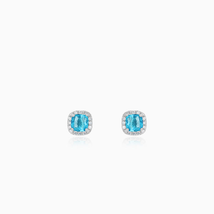 Sterling silver halo stud earrings with blue topaz