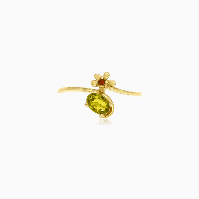Anillo de oro con moldavita ovalada y detalles florales con granates