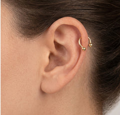 Two gold balls gold piercing