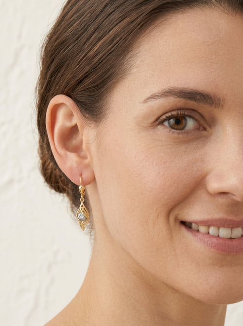 Dangling spiral gold earrings with a ball