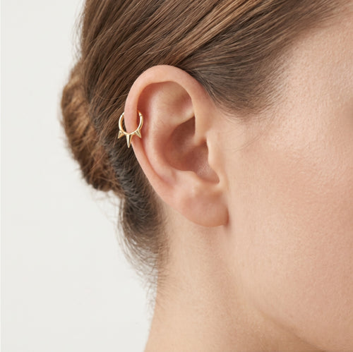Schickes Gold-Creolenpiercing mit drei Spikes