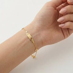 Pulsera de oro con detalles de flores y placa central