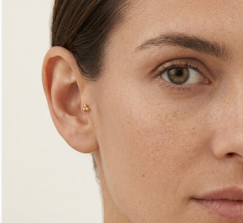 Elegant gold piercing with triple ball design