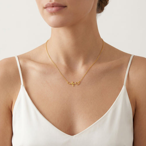 Gold necklace with heartbeat symbol