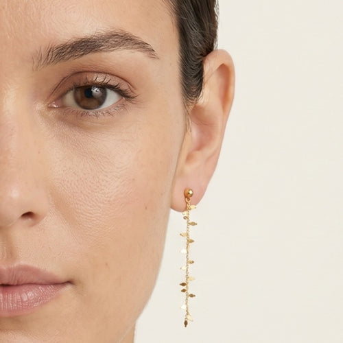 Gold earrings hanging with leaves