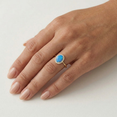 Ovaler Goldring mit blauem Opal und Halo