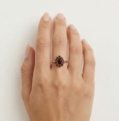 Anillo de Belleza de Granate con Halo Radiante en Oro Amarillo.