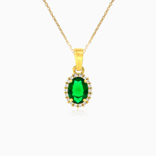 Oval cut emerald pendant with halo of cubic zirconia in yellow gold
