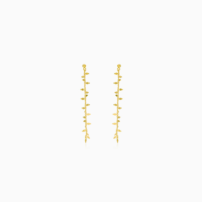Gold earrings hanging with leaves