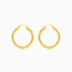 Twisted tube hoop earrings in yellow gold