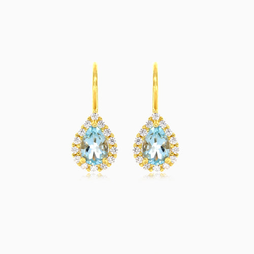Pear cut blue topaz halo earrings in yellow gold