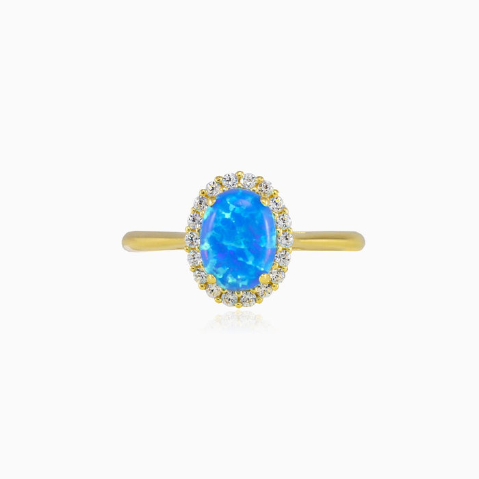 Anillo de oro con ópalo azul ovalado y halo